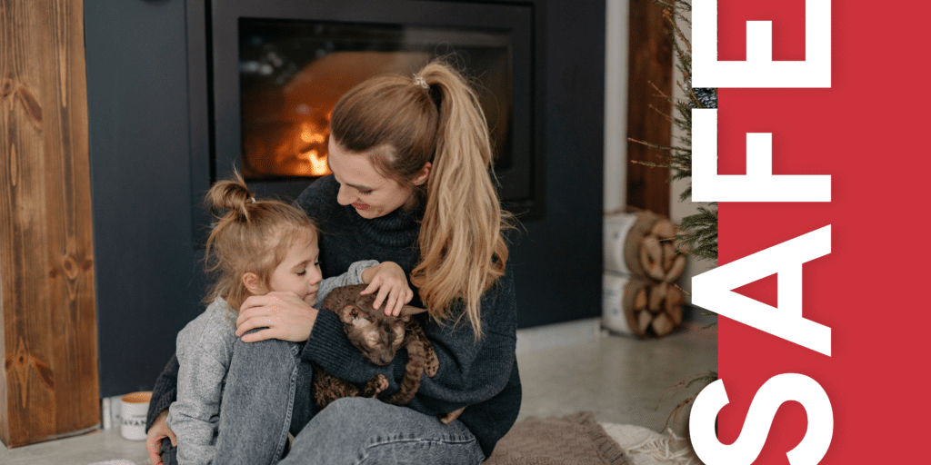 mother and child sit with their cat in front of a fireplace with the text overlay "safe"