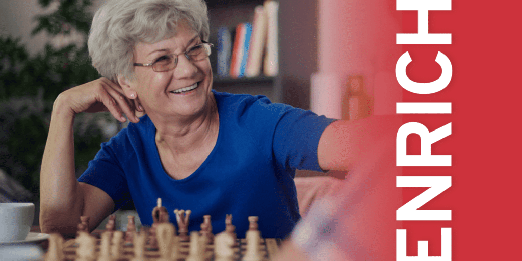 a senior woman plays chess cheerfully with the text overlay "enrich"