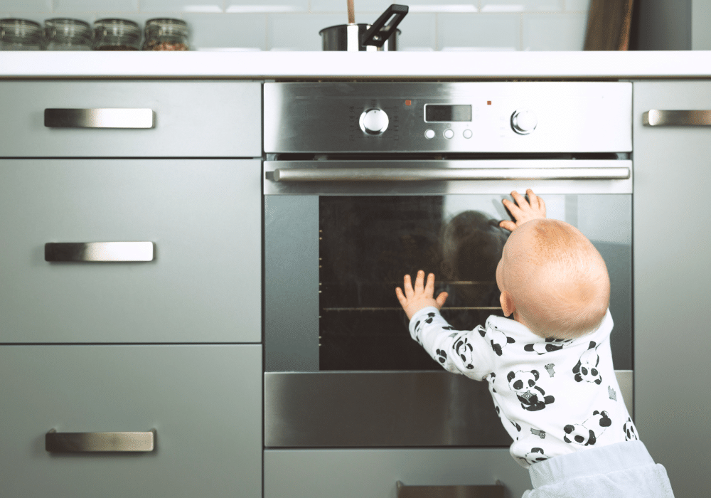 baby reaches towards stove for fire safety